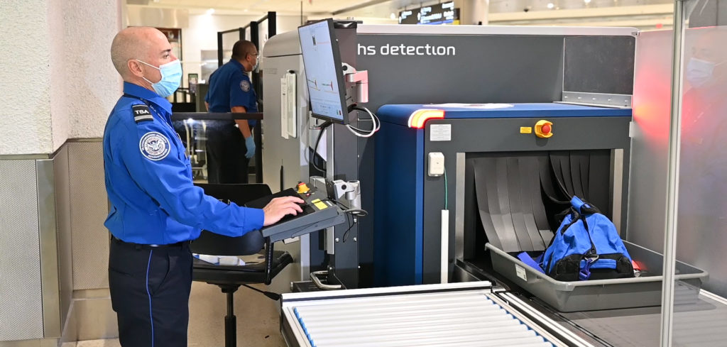 CT scanner capacity increased at Miami Airport news Miami International - TSA officer inspecting items using new CT technology