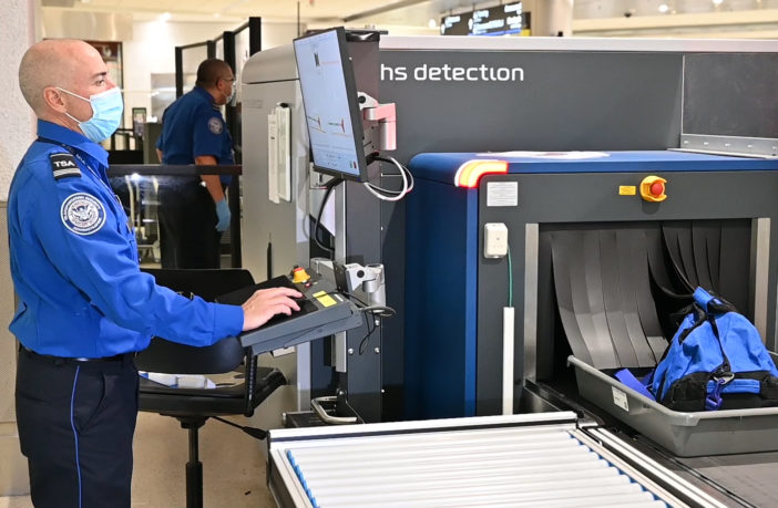 Airport news Miami International - TSA officer inspecting items using new CT technology