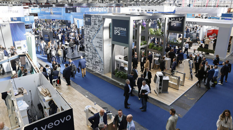 An aerial shot of a busy expo floor with blue carpet.