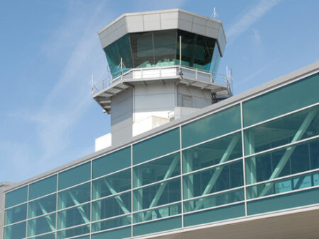 Bristol Airport invests in security scanners to meet new regulations The image shows Bristol Airport's walkway against a blue sky.