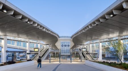 A passenger walks up to LAX/Metro Transit Center Station at dusk.
