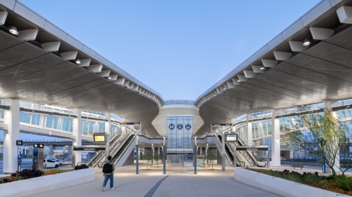 A passenger walks up to LAX/Metro Transit Center Station at dusk.