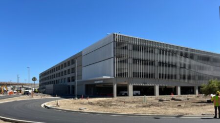 A grey building stands in front of a blue sky.