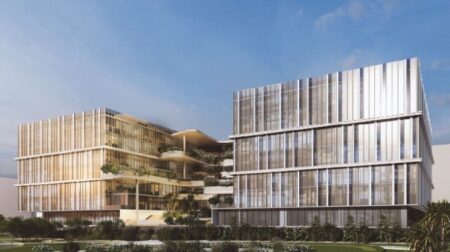 A render of a building clad in floor-to-ceiling windows stands in front of a blue sky.