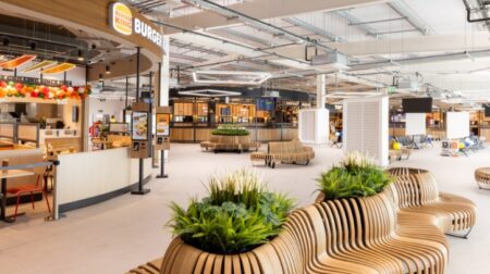 Leeds Bradford Airport completes first phase of £100m terminal expansion The interior of Leeds Bradford Airport’s new terminal expansion features a Burger King and an array of wooden seating with planters.