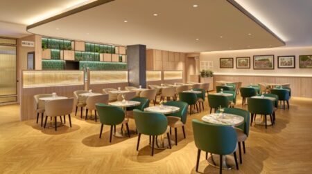 Senai International opens Plaza Premium Lounge Green chairs sit neatly around small tables in a wood-floor airport lounge.