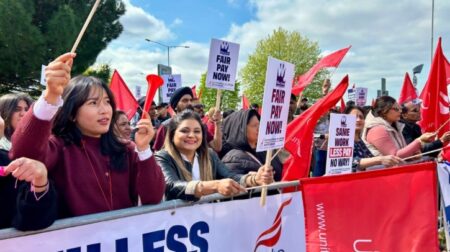 Striking passenger assistance staff at Heathrow win 12.5% pay increase A group of people cheer with signs that say, "FAIR PAY NOW!" and "SAME WORK LESS PAY NO WAY!"