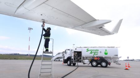 A technician refuels an aircraft with sustainable aviation fuel (SAF) at the airport.