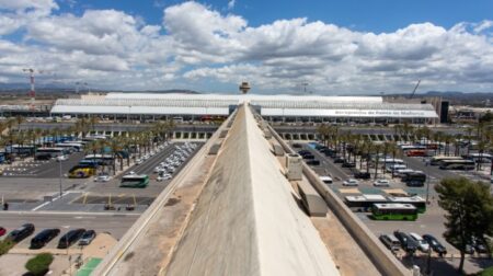 An aerial view of Palma de Mallorca Airport against a blue and cloudy sky.