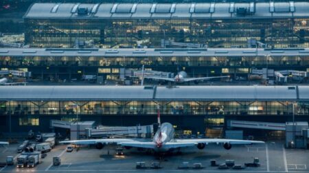Heathrow deploys another 540 cameras to support Assaia’s AI-powered turnaround system An aerial view of Heathrow Airport at night shows an airplane parked outside the terminal.