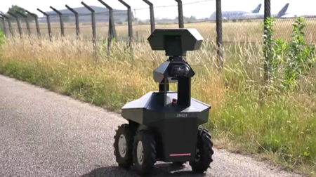 A robot patrols an airport fence.