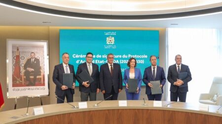 A row of executives in suits hold folders.