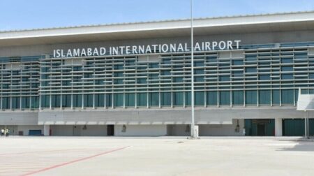 A building with lots of windows features the words, "Islamabad Airport" along the side.