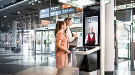 Two passengers face an airport e-gate.