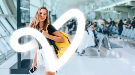 A passenger walks toward the camera enveloped by a stylized "V" logo.