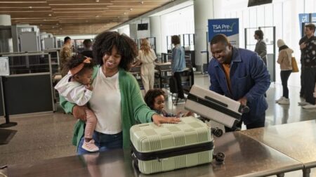 A mother and father with two children go through security screening at an airport