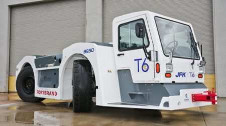 JFK International Airport T6 announces pooled electric ground support fleet An electric ground support vehicle with Fortbrand logo along the side and T6 on the driver's door, parked on the tarmac at an airport
