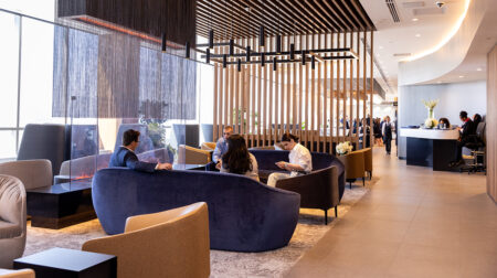 An American Airlines lounge with dark seating and a light brown wooden floor and stylish interior decor