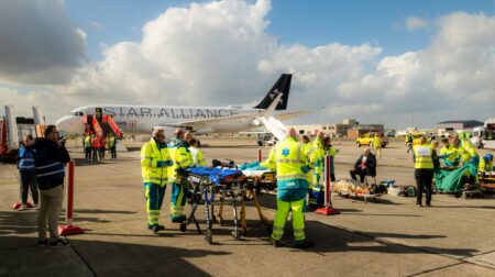 Emergency responders on the airport tarmac at Brussels Airport in hig-vis jackets as part of an emergency exercise with a plane in the background