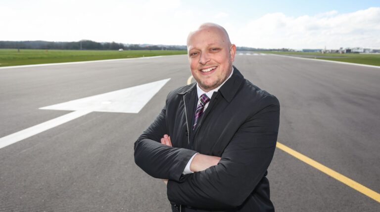 Glasgow Airport managing director Gavin Williams stands with his arms cross in a promo photo pose on the runway
