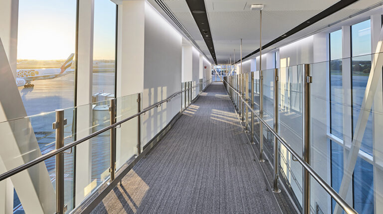 Australian airports collaborate to fight human trafficking An empty corridor at an airport terminal, with glass windows on either side looking out of the runways and ground operations