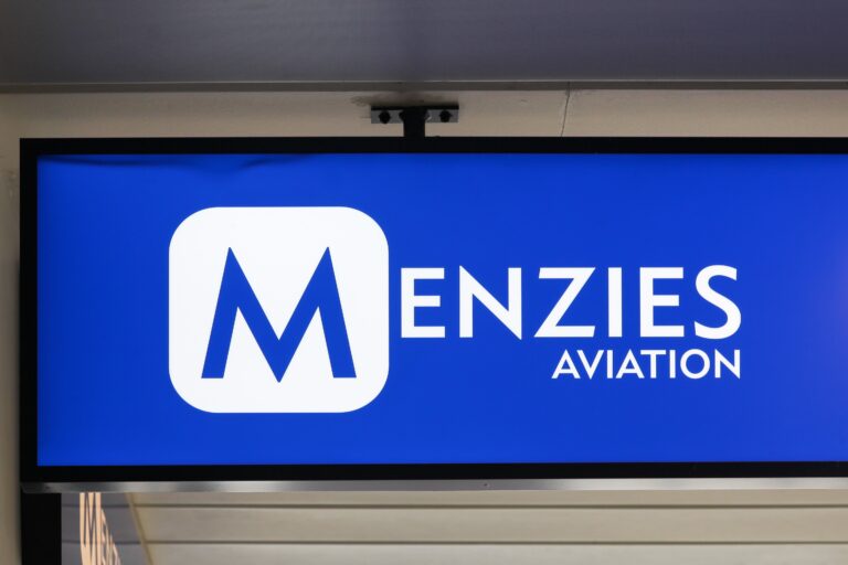 Menzies Aviation logo on a large screen in an airport terminal