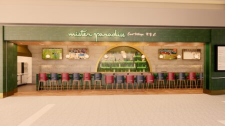 Artist render of the new Mister Paradise store in JFK airport in New York, with a row of seating along the front, an exposed brick wall behind the counter and a green strip across the top of the store with white brand writing