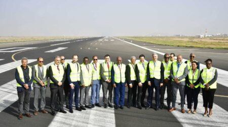 Vinci Airports announces further investments in Cape Verde after completing Phase 1A modernization program in 2025 Vinci Airports staff pose for a photo on an airport runway. They are wearing smart business attire an yellow high vis jackets