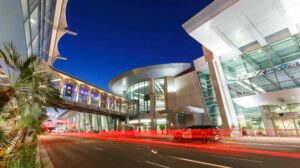 The entrance to San Diego airport (SAN) at night-time, with blurred red lights from automobiles passing in front.