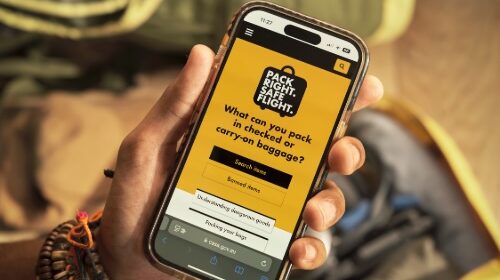 A passenger looks at the 'Pack Right. Safe Flight' mobile app on their smartphone.
