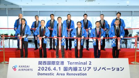 Kansai Airports representatives in dark suits and wearing blue gowns cut the ribbon to marek the oening of the new domestic area in Kansai International Airport's Terminal 2.