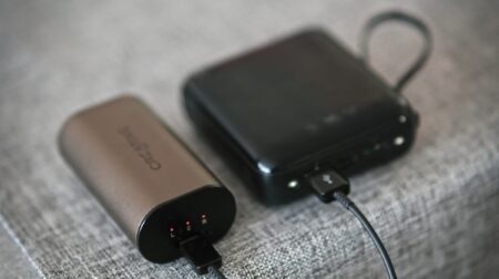 A small grey power bank and a large black power bank on a table.