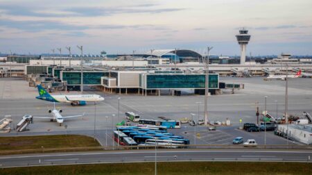 External aerial photograph of Munich Airport with the terminal in the centre and plans parked in the foreground.