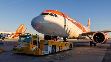 TaxiBot electric towing deployed at Amsterdam Schiphol for more efficient and sustainable ground operations An easyJet aircraft parked at a gate at Amsterdam Airport Schiphol with a yellow and white TaxiBot ground tug in the foreground.
