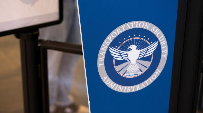 The TSA logo on a dark blue background on display on an airport concourse.