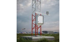 The Vaisala AWS810 Airport Edition automatic weather station in operation at an airport, with aircraft taxiiing along the runway in the foreground and background under a cloudy grey sky.