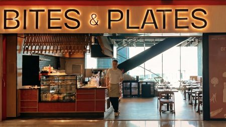 Exterior of the new Plaza Premium Group Bites & Plates at Helsinki Airport. It has an orange and brown frontage; a chef poses in the doorway.