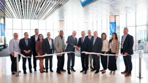 Representatives of DFW Airport and American Airlines cut a ceramonial ribbon to mark the opening of nine new gates at the airport.