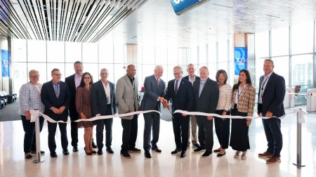 Representatives of DFW Airport and American Airlines cut a ceramonial ribbon to mark the opening of nine new gates at the airport.