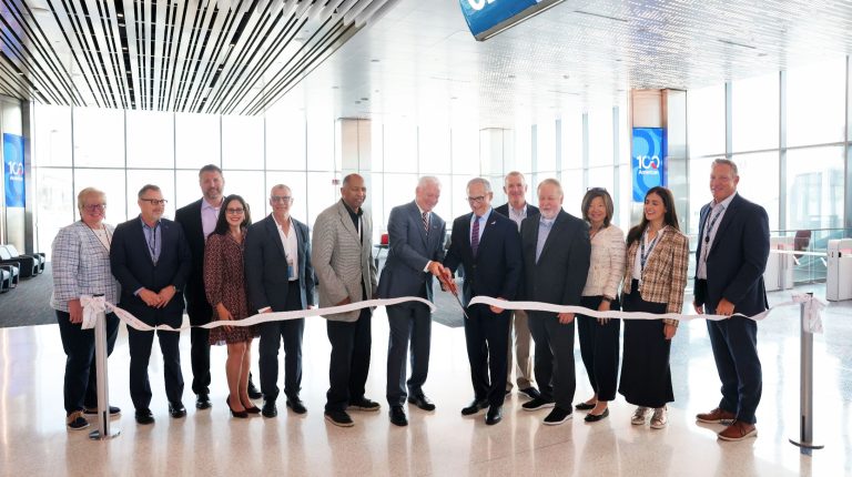 Representatives of DFW Airport and American Airlines cut a ceramonial ribbon to mark the opening of nine new gates at the airport.