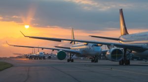 A line of aircraft on the tarmac at an airport tarmac.