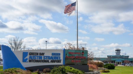 External front of Green Bay Austin Straubel International Airport, with an American flag flying.