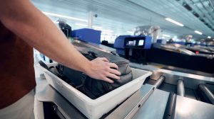 A piece of luggage is put into a tray for screening at airport security,