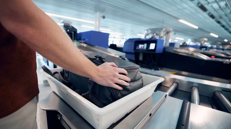 A piece of luggage is put into a tray for screening at airport security,