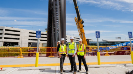 From left: Arts and culture manager Keny Marshall, artist Patrick Marold and public art consultant Renee Piechocki pose for a photograph in front of Marold’s ‘Open Columns’ piece during installation. (Photo by Beth Hollerich)