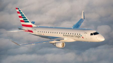 An American Airlines jet in flight above the clouds.