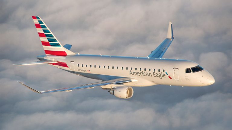An American Airlines jet in flight above the clouds.