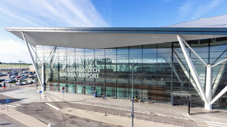 External entrance of Gdańsk Airport on a bright sunny day.