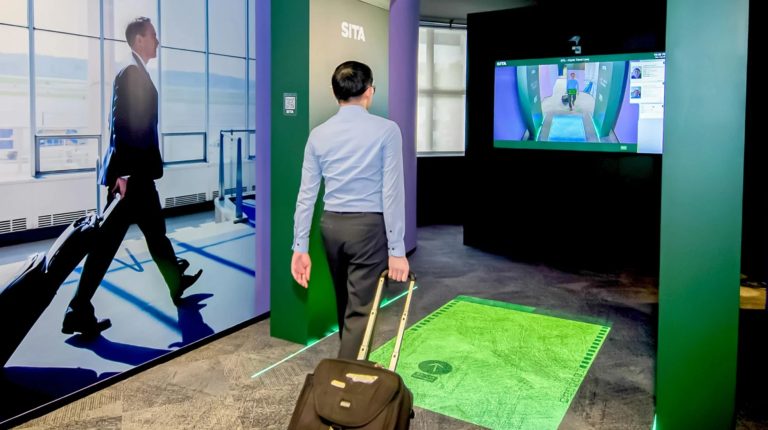 A passenger walks through a SITA pre-clearance border control lane at an airport.