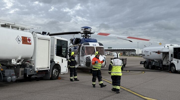 Emergency crews on apron with helicopter and fuel
